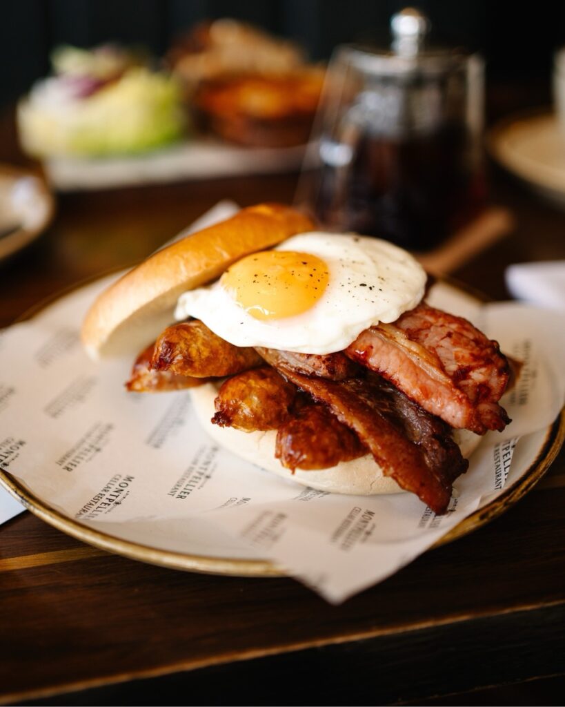 Hot breakfast bap with bacon, egg, sausage on a brioche bun served at the montpellier wine bar breakfast