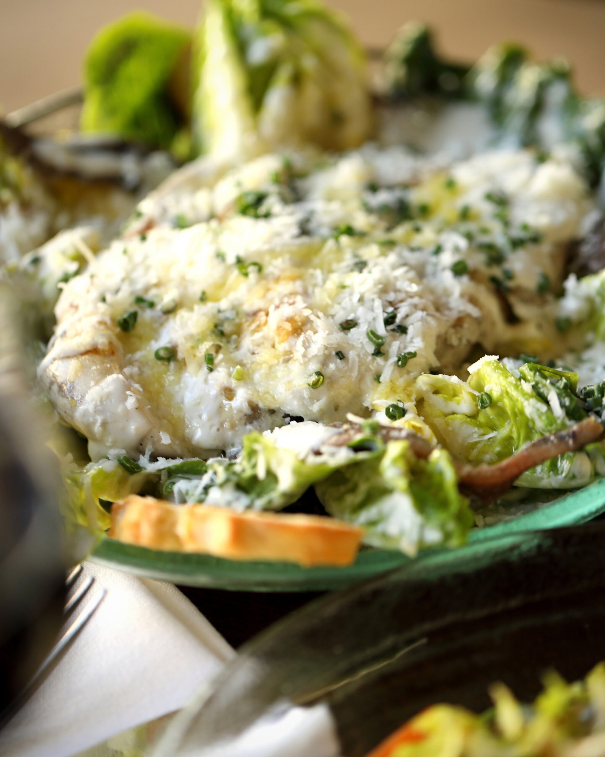 http://Close-up%20of%20a%20cheesy%20potato%20dish%20with%20chopped%20herbs,%20served%20on%20a%20plate%20with%20a%20slice%20of%20toasted%20bread%20nearby